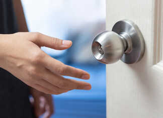 A hand about to grab a doorknob.
