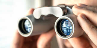 Binoculars being used to look out a window.