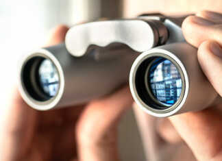 Binoculars being used to look out a window.